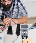 Man using Pro Grade Digital Display Soldering Iron Station Kit with Hot Air Rework for PCB maintenance