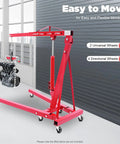 No Sweat Heavy Duty Folding Hydraulic Engine Hoist And Cherry Picker Shop Crane With Adjustable Leveler lifting an engine in a garage setting.