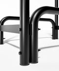 Close-up of black detachable round tube firewood rack log holder, steel frame joints, ideal for indoor and outdoor fireplaces.