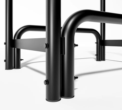 Close-up of black detachable round tube firewood rack log holder, steel frame joints, ideal for indoor and outdoor fireplaces.