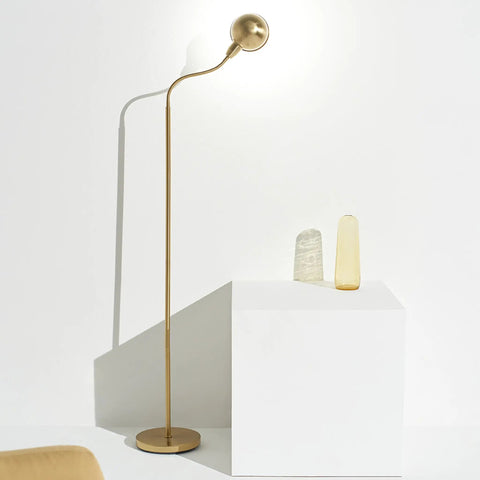 Slim LED Floor Lamp With Adjustable Gooseneck Free Standing Corner Pole Light in brass gold next to modern decor on white pedestal.