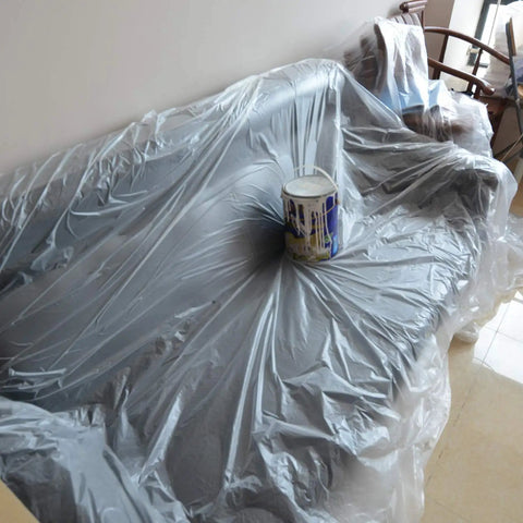 Heavy Duty Disposable Painter Drop Cloths 9x12 Feet Waterproof Clear Plastic Tarp For Painting Couch And Furniture Protection Anti Tear No Leak Guarantee Easy Cleanup Includes Gloves With 10 Individual Packs covering a couch.