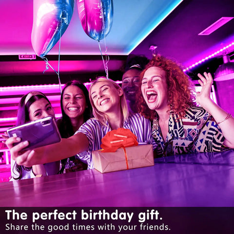 Group of friends celebrating with 50ft Music Synchronized LED Strip Lights For Bedroom And Home Decor, vibrant colors.