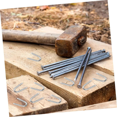 50 Pack U Shaped Fence Staples For Quick Install And Strong Hold Durable Metal Garden Stakes on wooden surface with hammer