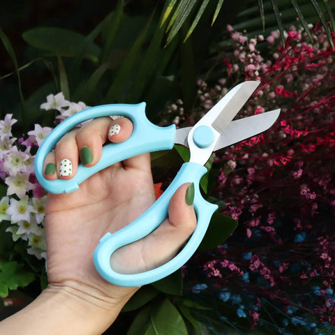 Pro Grade Garden Pruning Scissors With Comfort Grip Handle Set Razor Sharp SK5 Stainless Steel Floral Scissors in hand among flowers