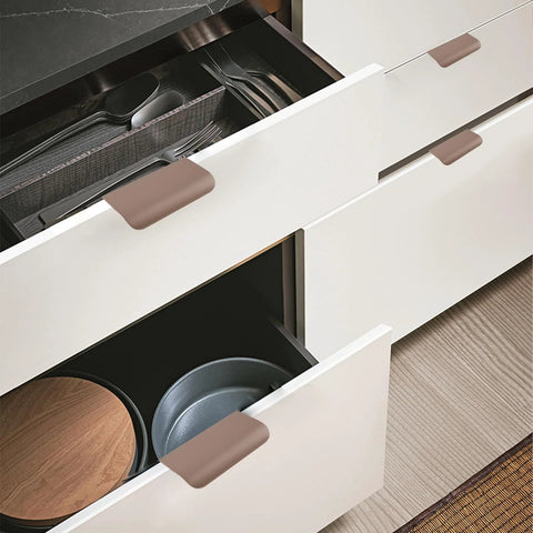 Image of Finger Edge Pulls Self-Adhesive 8 Pack Concealed Cabinet Drawer Handles Modern Curved Aluminum Alloy, brown, installed on white drawers.