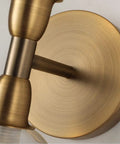 Close-up of a gold fixture on the Rock This Mini Two Light Gold Bathroom Vanity Wall Sconce With Clear Glass Shades