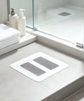 Hair Drain Stickers Disposable Hair Catcher for Shower Drain placed on shower floor with towels and soap bottles.