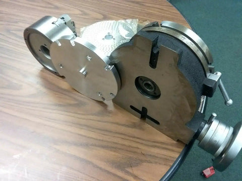 8 Inch Precision Horizontal Vertical Rotary Table With 6 Inch Three Jaw Chuck showing detailed gears and clamping components on a wooden table.