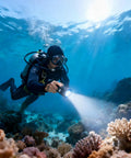 Diver using Beast Bright Dive Light Underwater Flashlight 1500 Lumens with Charger IPX8 Waterproof to 100m among coral reefs