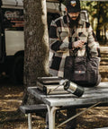 Man outdoors with Dual Fuel Camping Stove For Propane Or Butane With Piezo Ignition, Portable Stove With Carrying Case And Regulator on table