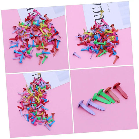 Assorted colored metal miniature brads on pink surface, part of the 300Pcs Miniature Brads Round Fasteners For Crafts DIY Projects Scrapbooking Card Making Dreadlock Accessories And Creative Craft Supplies For Kids And Adults.