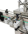 Close-up of Badass Auto Liquid Filling Machine With Single Head Servo Pump and Steel Conveyor Belt components and valves.