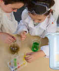 Children conducting an experiment with Lab Beaker Set 3.3 Borosilicate Glass Low Form Pack Of 5, focusing on 1000 mL beaker.