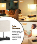 Set Of 2 Dimmable Beige Bedside Lamps With USB C Ports And Dual Charging Outlets, shown in living room with phone stand