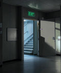 Two Pack Glow In The Dark Aluminum Exit Signs 12x7 Inches Photoluminescent Laminated For UV Weather And Fade Resistance Built Tough Easy To Spot Indoors And Outdoors For Office School Warehouse Business Fire Exit Sign on a lit hallway exit