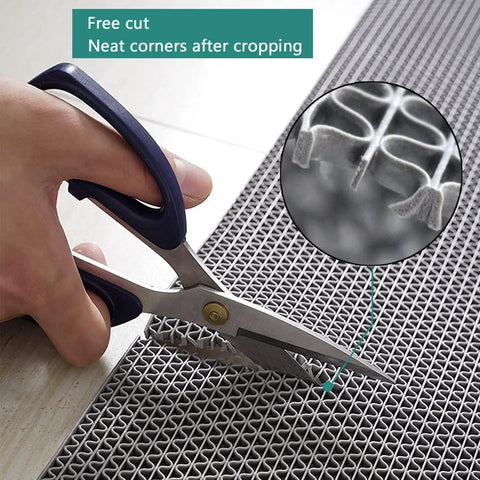 Person cutting a gray Commercial Drainage Mat 3x10 Ft 0.22 Inch Thick Grippy Non Slip PVC Floor Rug with scissors, showing easy trimming.