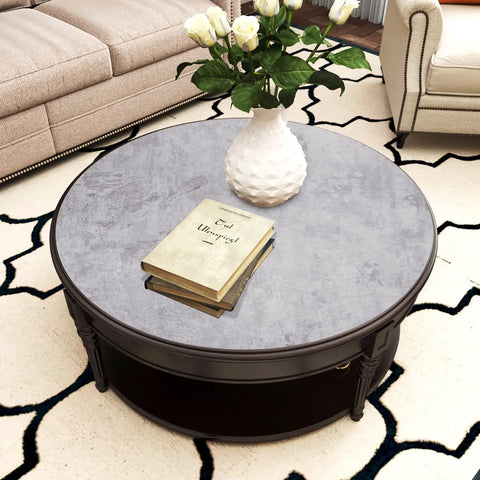 Coffee table with Textured Cement Countertop Contact Paper Peel And Stick Grey Concrete Vinyl Film applied, books and vase on top.
