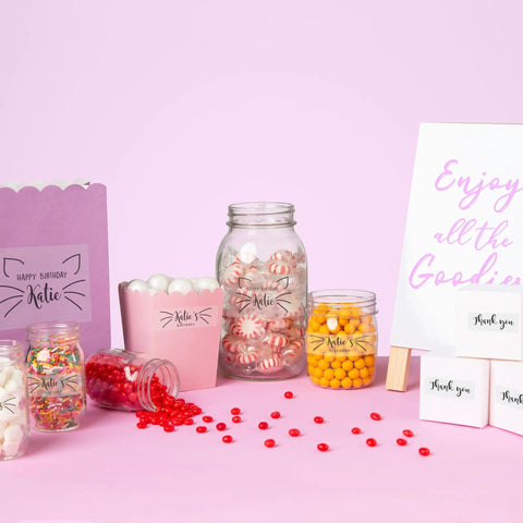 Image featuring a birthday party setup with candy jars, a gift bag, and decoration for Katie's birthday celebration.