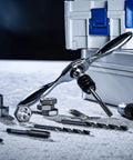 Reversible Ratcheting T Handle Tap Wrench with accessories on surface, perfect for automotive threading jobs.