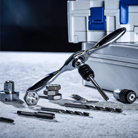 Reversible Ratcheting T Handle Tap Wrench with accessories on surface, perfect for automotive threading jobs.