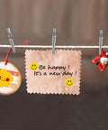 Heavy Duty 50mm Metal Alligator Clips 50 Pack holding a note saying 'Be happy! It's a new day!' with smiley faces, cheerful decoration