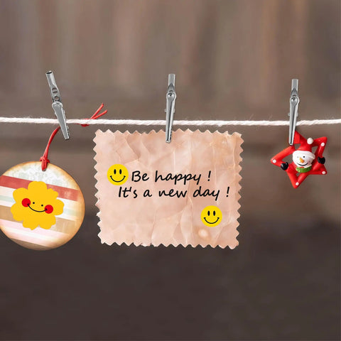Heavy Duty 50mm Metal Alligator Clips 50 Pack holding a note saying 'Be happy! It's a new day!' with smiley faces, cheerful decoration