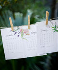 Large Wooden Clothes Pins 2.9 Inch 50 Pack Built Tough Galvanized Coil Springs holding monthly calendars on twine.