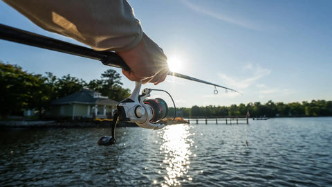 Angler casting with Max Pro Spinning Rod And Reel Combo 6 Foot 10 Inch, Size 2500 Reel, by a sunny lakeside