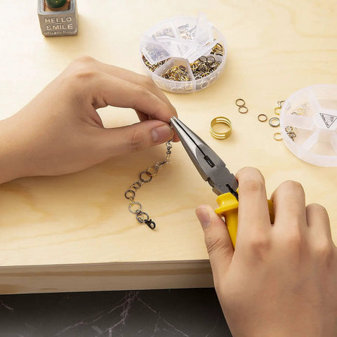 Hands using pliers on necklace with Over 1000 Open Jump Rings Kit With 40Pcs 12Mm Lobster Clasps And Jump Ring Opener in gold finish