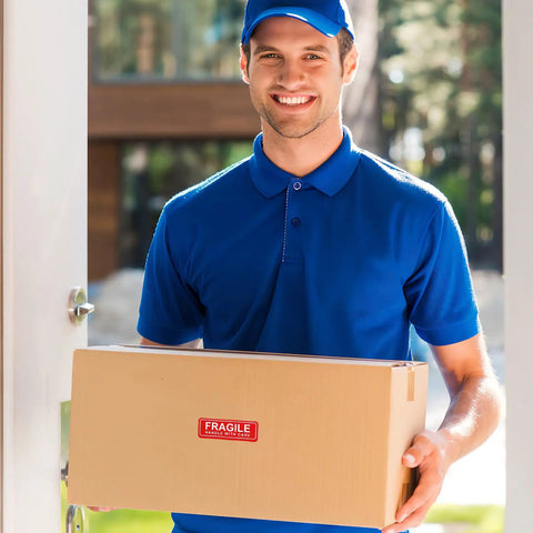 Delivery person holding a box with Red Fragile Stickers, 150-Count Self-Adhesive Paper Labels For Packing And Shipping, Handle With Care