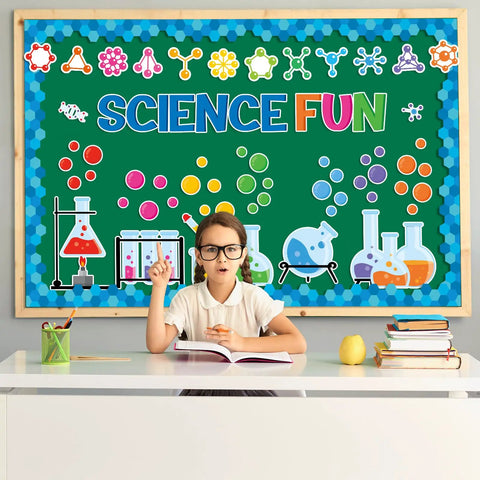 Child in front of Totally Fun Science Bulletin Board Decor Kit with Chemistry Lab Cutouts, colorful symbols, and Science Fun letters.