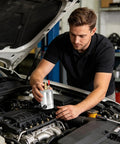 Man installing a 300Ml Double Port Oil Catch Can Kit With Innovative Baffle Plate Design in a car engine bay.