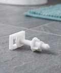 White ABS plastic bolt from 10 Pieces Universal Toilet Seat Bolts Kit With Nuts And Washers In ABS Plastic, on bathroom floor