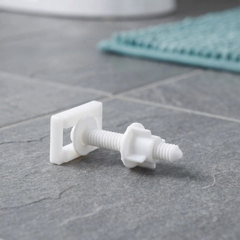 White ABS plastic bolt from 10 Pieces Universal Toilet Seat Bolts Kit With Nuts And Washers In ABS Plastic, on bathroom floor