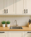 Kitchen cabinet with Solid Brass Cabinet Pulls 4 Pack Matte Black Euro T Bar Handles With 5 Inch Hole Center installed, above sink area.