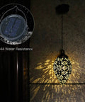 2 Pack Hanging Solar Lights With Moroccan Olive Pattern Lanterns illuminating a wall, highlighting IP44 waterproof feature.
