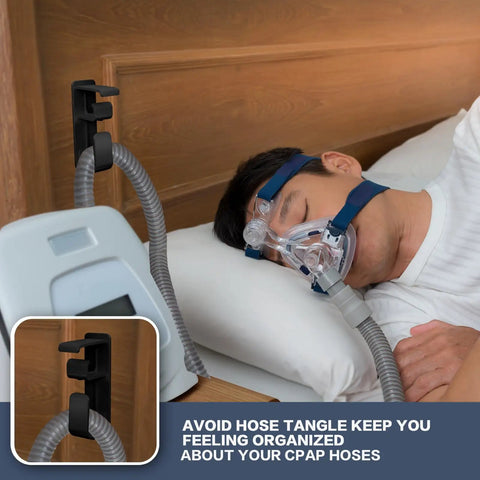 Double Hook CPAP Hose Holder And Mask Hanger For Bed Mounts With Anti Skid Base, shown mounted to bed with CPAP mask in use