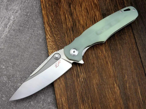 Fast Opening Ball Bearing Folding Knife With Pocket Clip D2 Steel Blade G10 Handle in Jade Finish on wooden surface