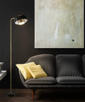 Felipe Floor Lamp With Tilting Head, Antique Brass Finish And Matte Black Accent, next to modern sofa in living room