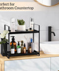 Two-tier black shelf organizer on bathroom counter with lotions and green plant, suitable for Coffee Station Organizer For Counter