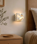 4.7" Mid Century Modern Wall Sconce, Minimalist Terrazzo Wall Light Fixture glowing beside a bed with soft shadows.