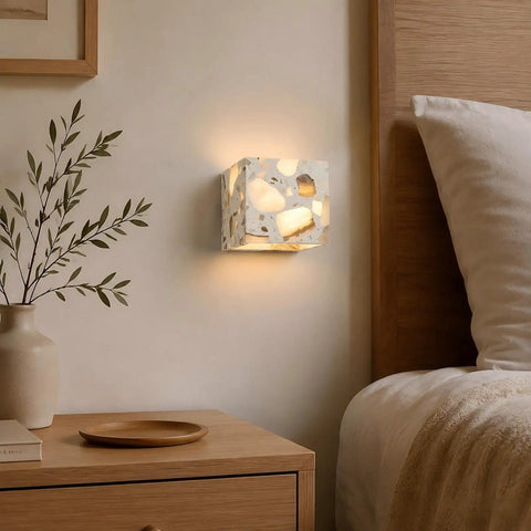 4.7" Mid Century Modern Wall Sconce, Minimalist Terrazzo Wall Light Fixture glowing beside a bed with soft shadows.