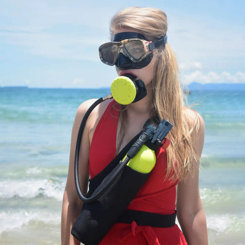 Person using Mini Scuba Tank 1L For Diving With 10-15 Minute Air Supply DOT Certified Lightweight Aluminum Tank on a beach.