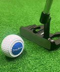 Golf putter next to Game Changing Putting Wheels Training Aid Set Of 3 For True Roll Practice Golf Alignment Tool on green surface.
