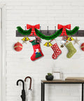 Rustic 34 Inch Wall Mounted Coat Rack With Ten Decorative Hooks Heavy Duty Pine Wood Rail For Entryway Or Living Room Holds Up To 15 Lbs Per Hook Old Wood Color Farmhouse Style with holiday decorations, stockings, and ornaments, installed on a white brick wall.