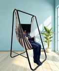Weatherproof Hammock Chair Stand With Hanging Swing Chair Included, Rugged Iron Frame Supports Up To 450 Lbs in a sunny room