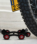 Amosfun Motorcycle Tire Dolly Tool With Five Smooth Wheels Heavy Duty Vehicle Mover under a tire in a garage setting.