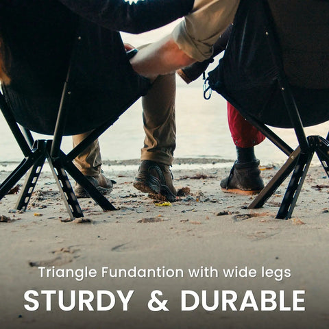 Back view of two people seated on Ultra Lightweight Backpack Chair With 5 Second Folding, Grab And Go Packable Camp Chair, black legs on sandy ground