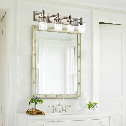 Four Light Vanity Light In Brushed Nickel With Clear Glass Shades mounted above a bathroom mirror